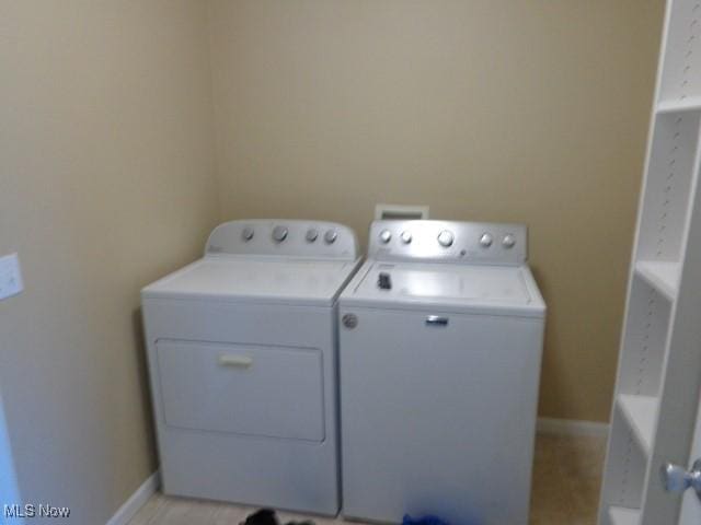 washroom featuring washer and dryer, laundry area, and baseboards