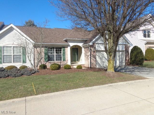 ranch-style house featuring driveway, an attached garage, and a front lawn