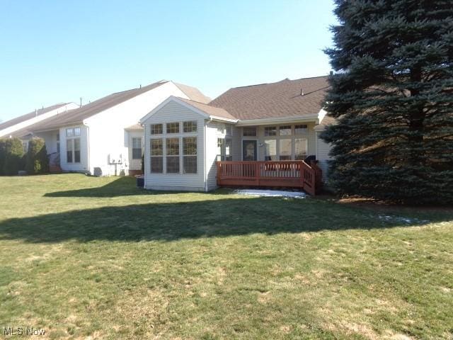 rear view of property with a lawn and a wooden deck