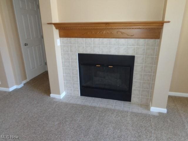 details featuring a tile fireplace, baseboards, and carpet floors