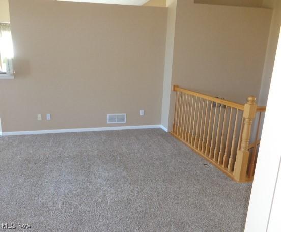 unfurnished room featuring baseboards, visible vents, and carpet floors