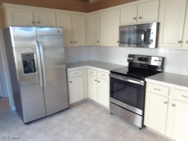 kitchen with stainless steel appliances, backsplash, and light countertops