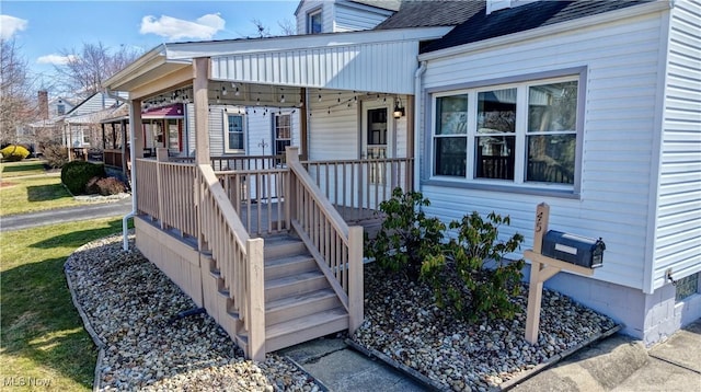 doorway to property featuring a porch and roof with shingles