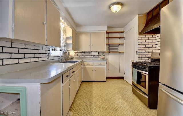 kitchen featuring open shelves, light floors, light countertops, stainless steel appliances, and a sink