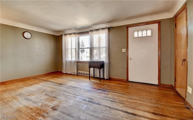 entryway with wood finished floors, visible vents, and baseboards