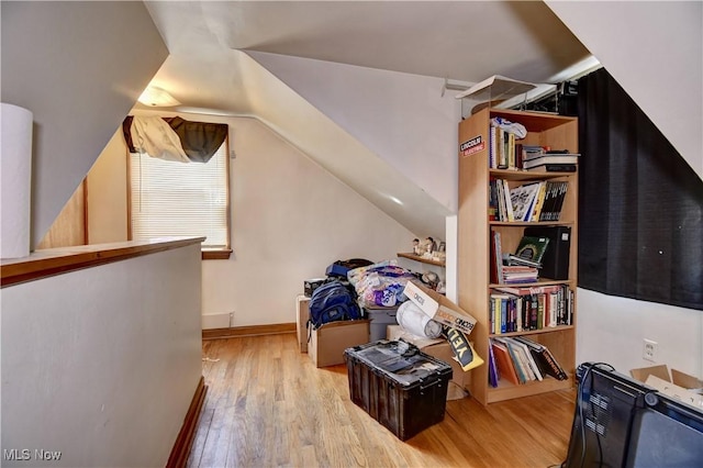 additional living space featuring lofted ceiling and wood finished floors