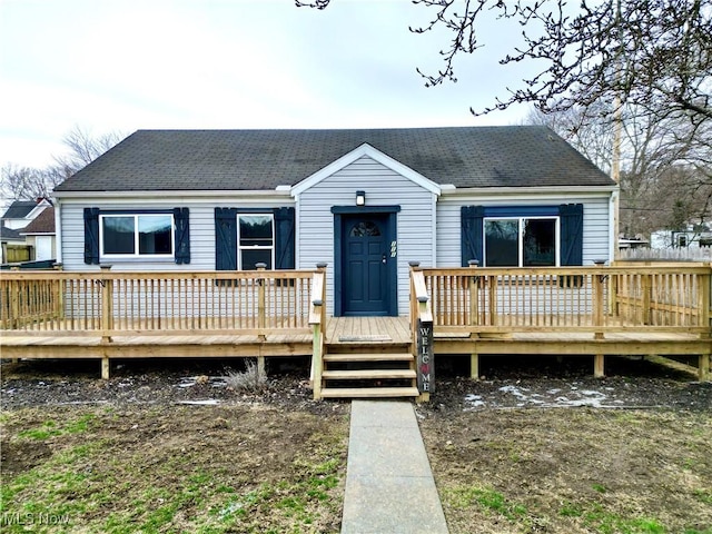 view of front facade featuring a deck and a shingled roof