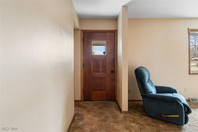 doorway to outside with visible vents, baseboards, and carpet