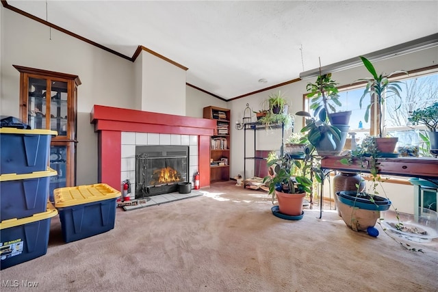 living room featuring a tiled fireplace, carpet flooring, lofted ceiling, and ornamental molding