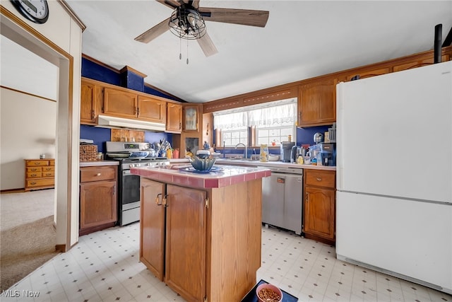 kitchen with light floors, a kitchen island, stainless steel appliances, light countertops, and under cabinet range hood