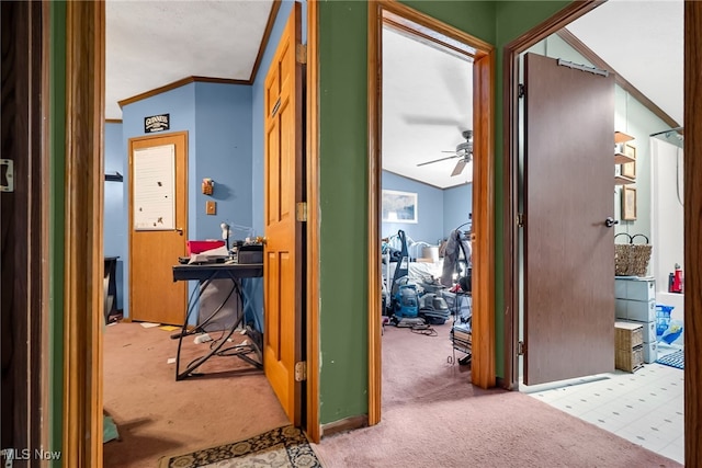 hallway with carpet floors, lofted ceiling, and ornamental molding