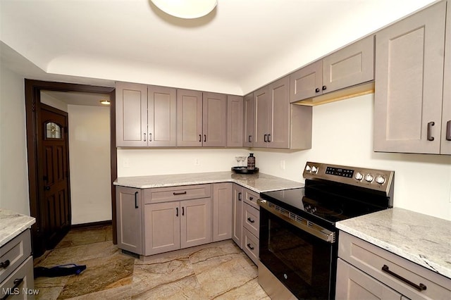 kitchen with light stone counters, gray cabinetry, and electric stove