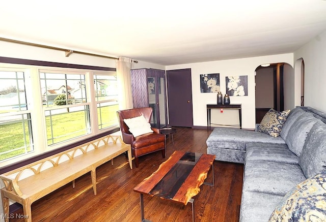 living room featuring arched walkways and wood finished floors