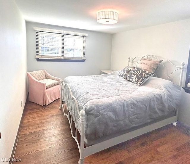 bedroom with baseboards and wood finished floors