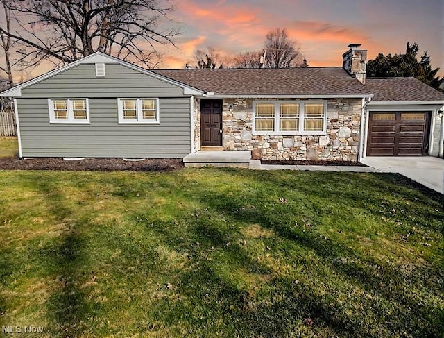 ranch-style home with driveway, a chimney, stone siding, a garage, and a lawn