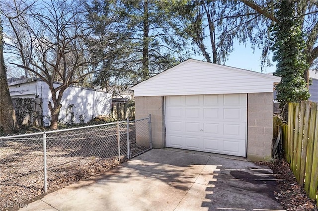 detached garage with concrete driveway and fence