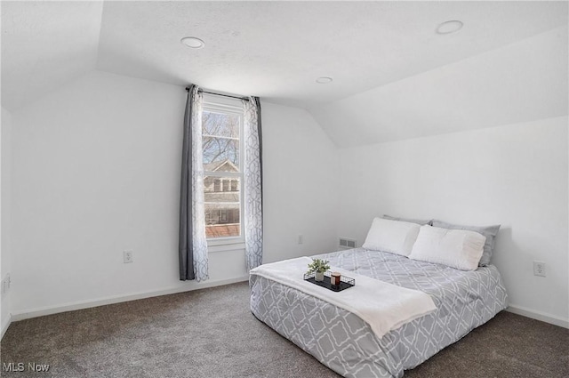 carpeted bedroom featuring visible vents, lofted ceiling, and baseboards