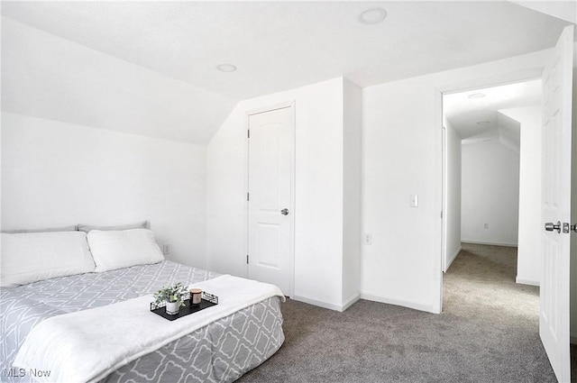 bedroom featuring baseboards, carpet, and vaulted ceiling