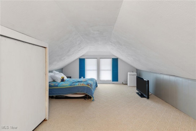 carpeted bedroom with a textured ceiling and lofted ceiling