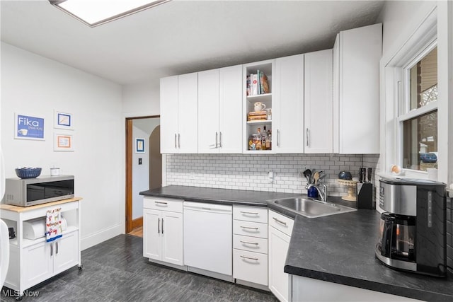 kitchen featuring a sink, open shelves, dark countertops, white cabinets, and white dishwasher