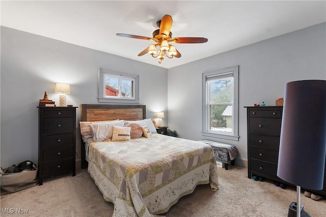 bedroom with ceiling fan and light carpet