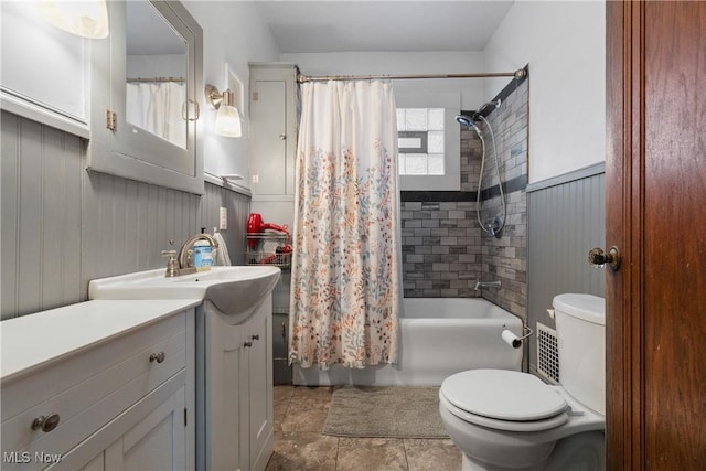 bathroom featuring wainscoting, toilet, shower / bath combo, and vanity