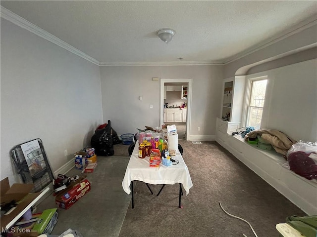 interior space featuring crown molding, carpet flooring, baseboards, and a textured ceiling