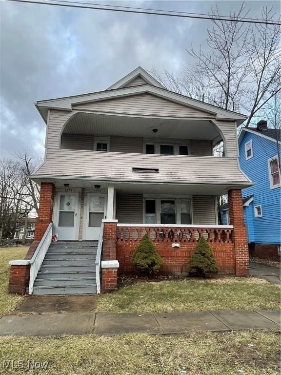 view of front of home with a porch and brick siding