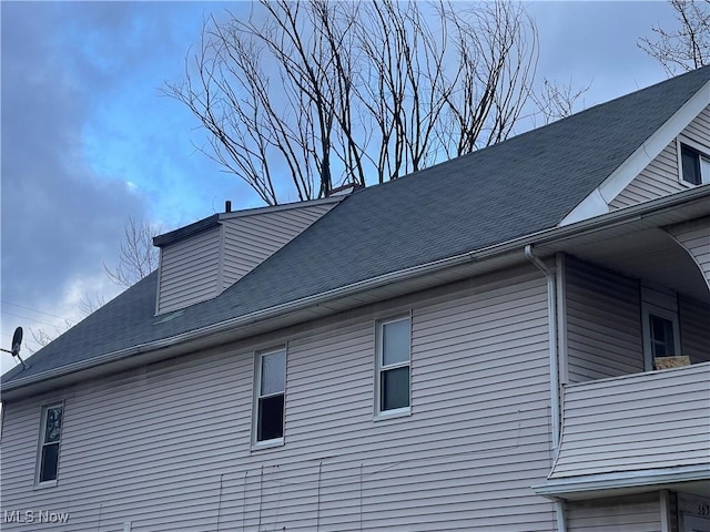 view of property exterior with a shingled roof