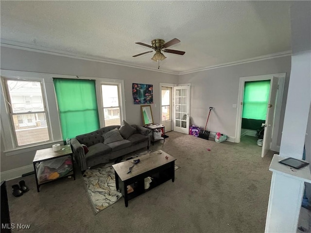 carpeted living room with baseboards, a textured ceiling, crown molding, and ceiling fan