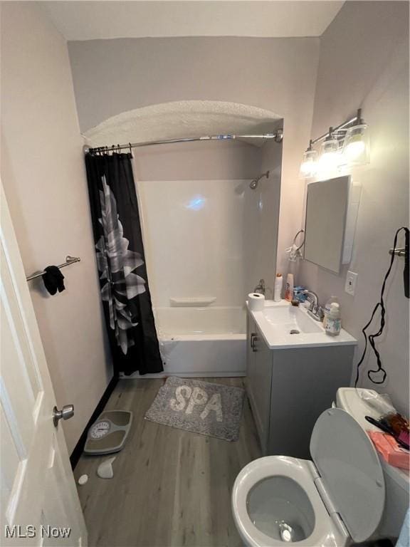 full bathroom featuring vanity, toilet, wood finished floors, and shower / bath combo