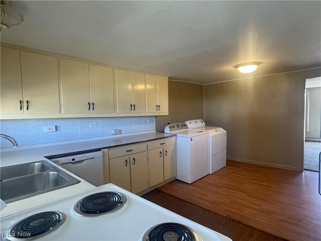 washroom with laundry area, washing machine and dryer, wood finished floors, and a sink