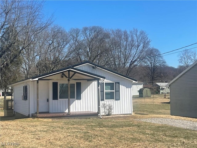 view of front facade featuring a porch, a front lawn, and board and batten siding