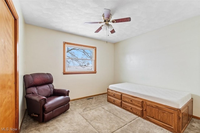 sitting room with light carpet, a ceiling fan, and baseboards