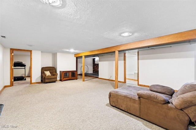 finished below grade area with visible vents, baseboards, carpet floors, and a textured ceiling