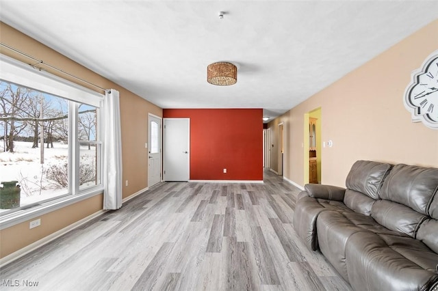 unfurnished living room featuring light wood-style flooring and baseboards