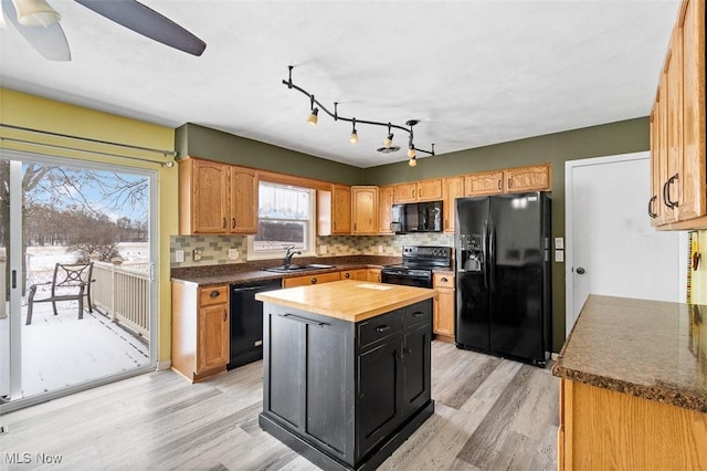 kitchen featuring black appliances, a sink, wood counters, light wood-style floors, and decorative backsplash