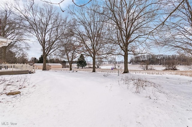 yard layered in snow with a wooden deck