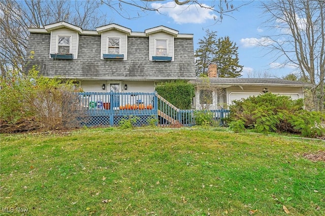 view of front of home with a deck, an attached garage, a front lawn, and roof with shingles