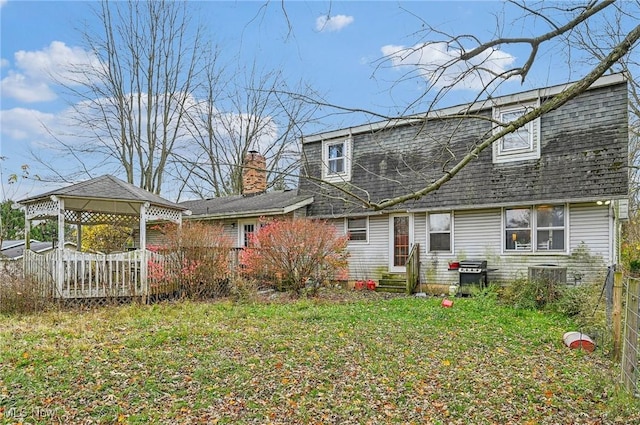 back of house with a gazebo, central air condition unit, roof with shingles, and entry steps