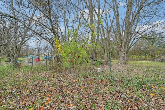 view of yard featuring an outbuilding and fence