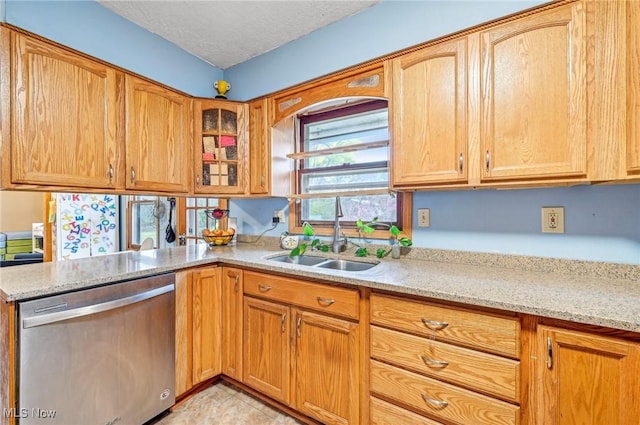 kitchen featuring a sink, light stone counters, a textured ceiling, glass insert cabinets, and dishwasher