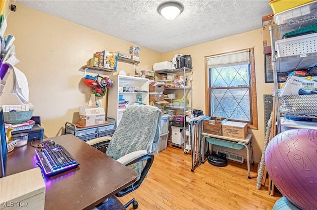 home office featuring wood finished floors and a textured ceiling