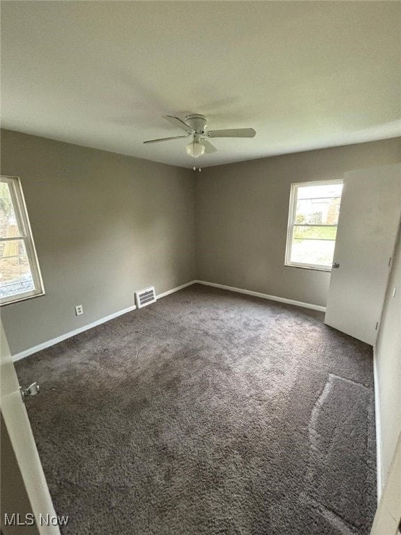 spare room with visible vents, ceiling fan, baseboards, and carpet