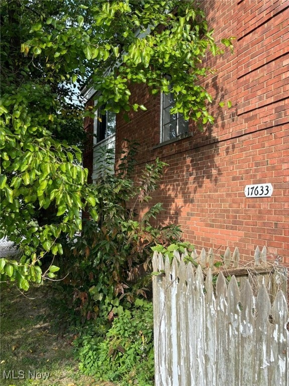 view of home's exterior featuring fence and brick siding