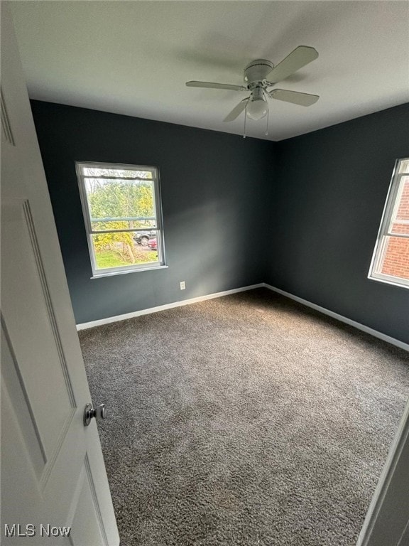 carpeted spare room with baseboards and ceiling fan