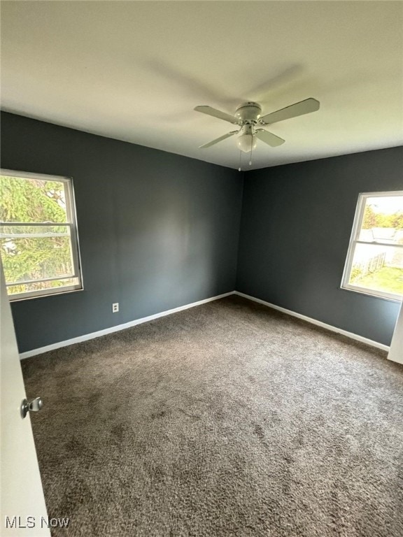 unfurnished room with a wealth of natural light, baseboards, and carpet