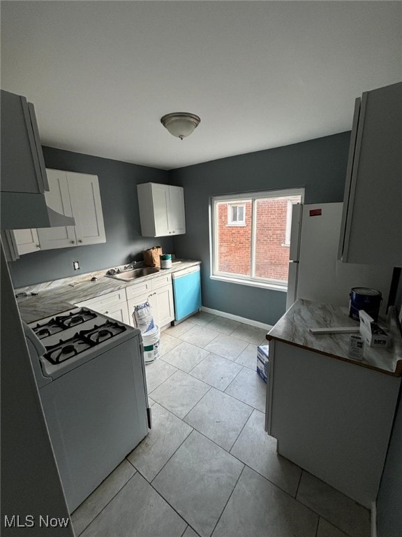 kitchen with range with gas stovetop, dishwashing machine, freestanding refrigerator, a sink, and white cabinets