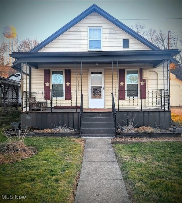 bungalow with a porch and a front lawn