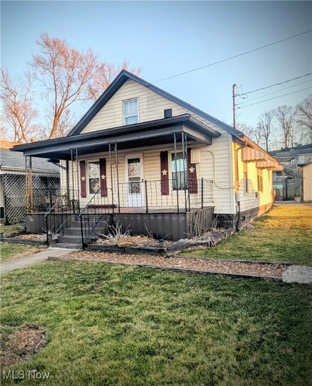 view of front of home with a porch and a front lawn